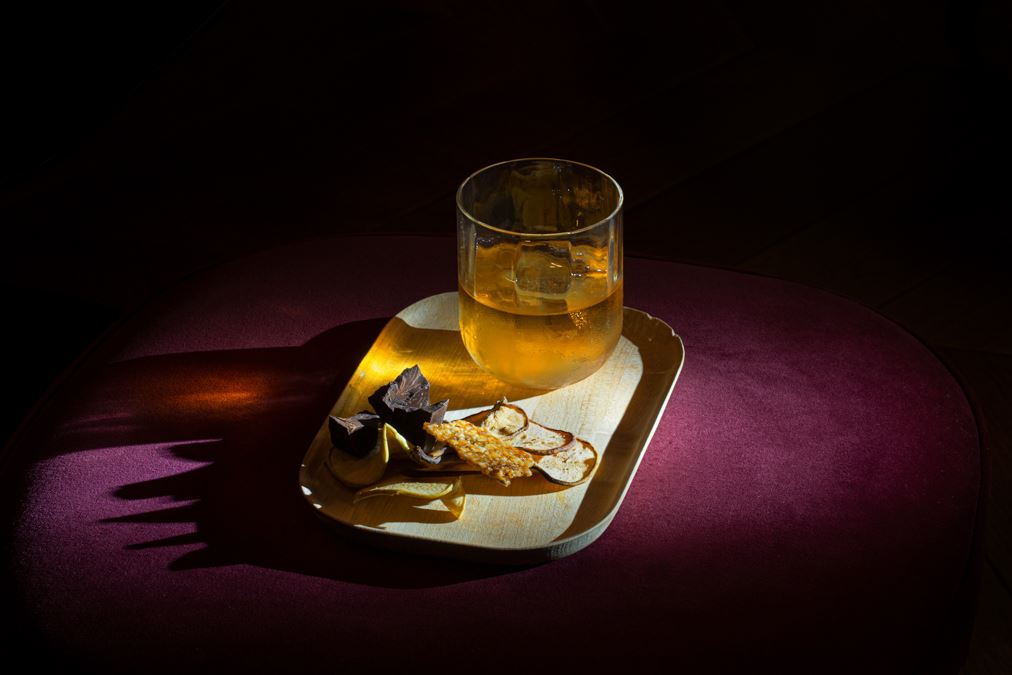 Cocktail illuminato dalla torcia su una sedia di velluto.