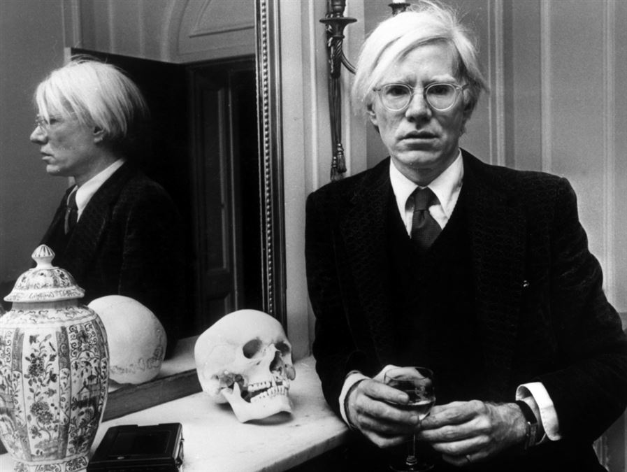 Warhol in posa con uno dei simboli ispiratori della sua arte